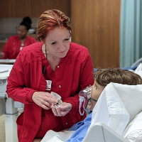 Female nursing student practicing skills on simulated patient